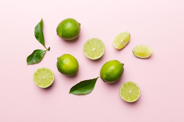 Lime fruits with green leaf and cut in half slice isolated on white background Top view Flat lay with copy space