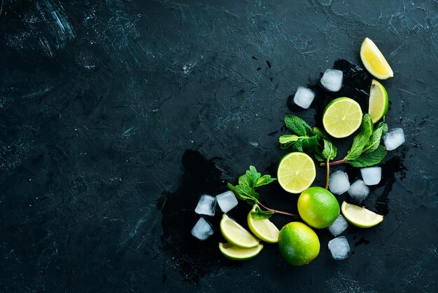 Lime ice and mint on a black stone background Top view Free space for your text