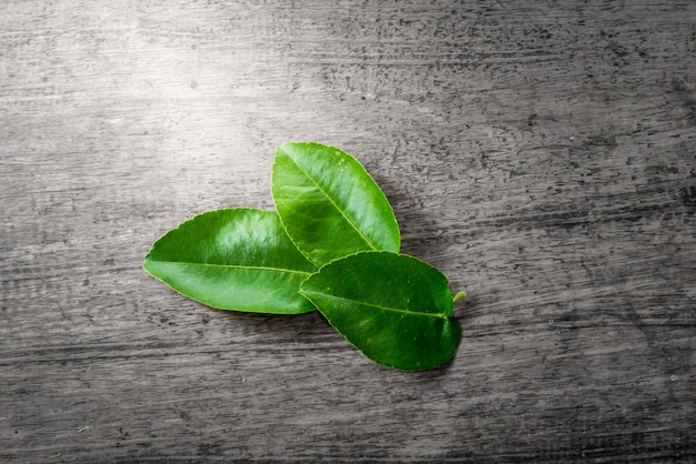 Lime leaves on wooden background