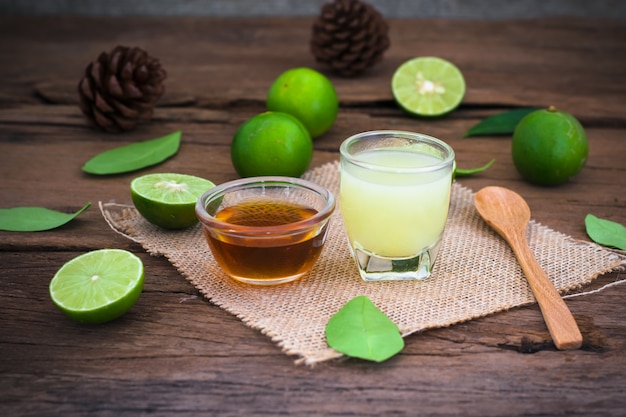 Lime lemon with juice and honey in transparent glass with sack cloth