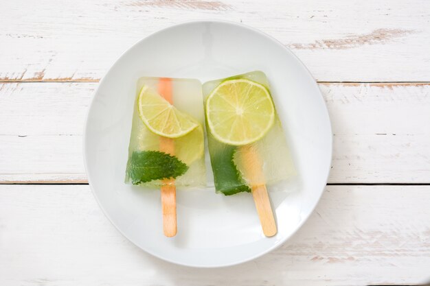 Lime popsicle on white wooden table