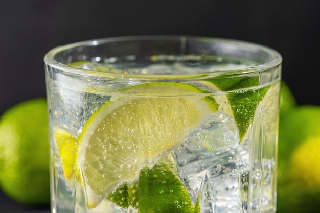 Foto fetta di lime con acqua frizzante in un bicchiere.