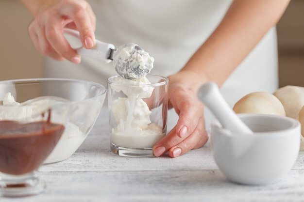 Lime and vanilla ice cream in a cup with mint and wooden spoon