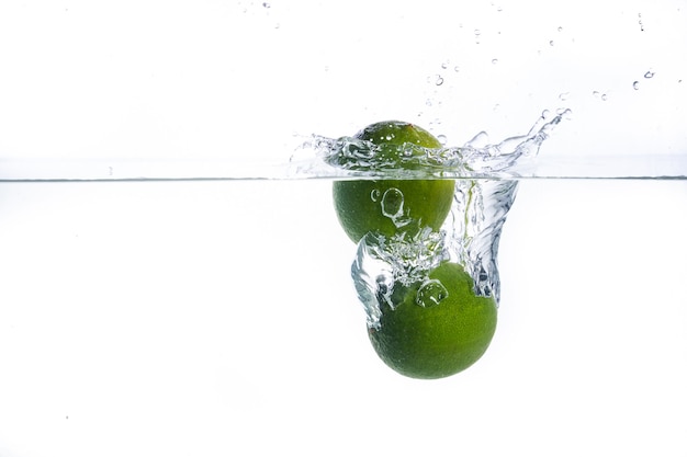 Lime in water. Close up, white background