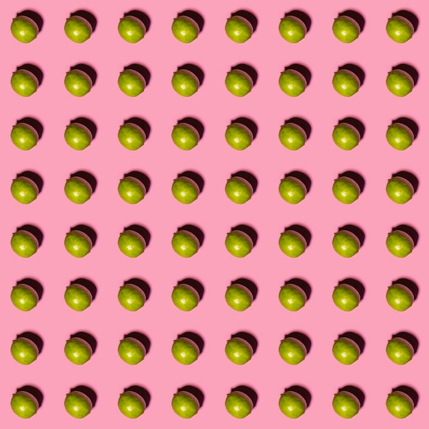 Limes pattern on pink background Creative food concept Flat lay