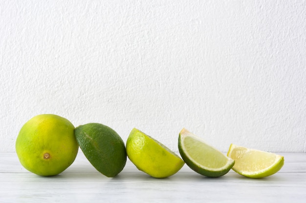 Limes on a white wood table copy space