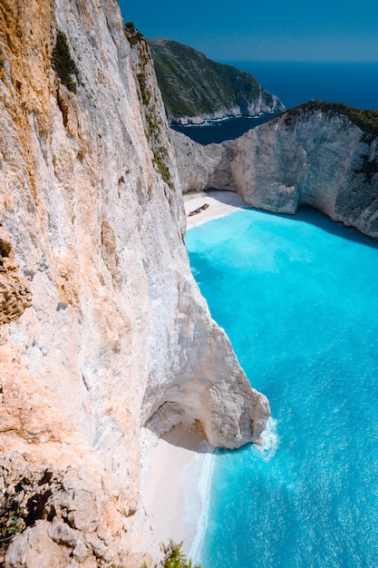 Limestone chalk colored like huge cliff rocks surrounding Navagio beach with Shipwreck and