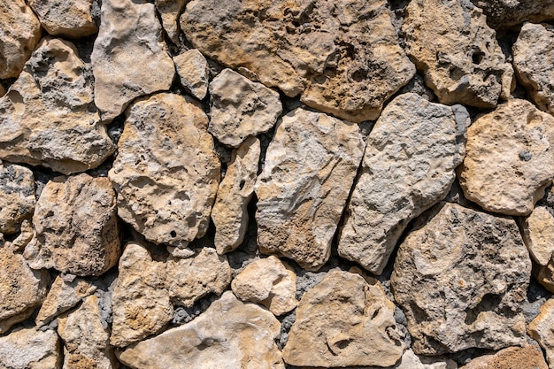 石灰岩の石積み-壁は野生の石でできています。表面は天然素材で装飾されています。