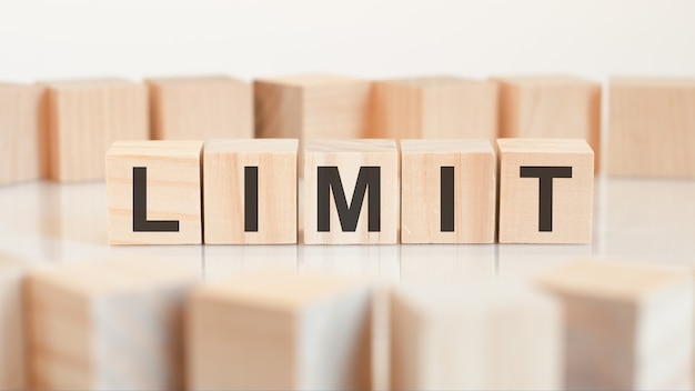 Limit - wooden letters on the office desk, white background, concept