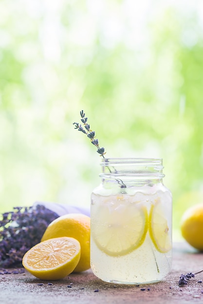 Limonade met citroenen en lavendel op stenen tafel over de natuur