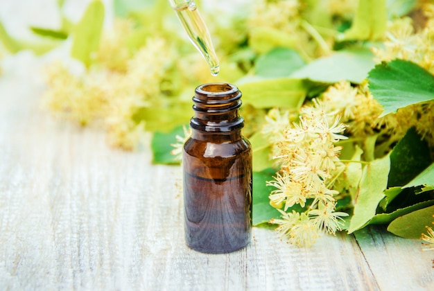 Linden extract and flowers in a small bottle. Selective focus.