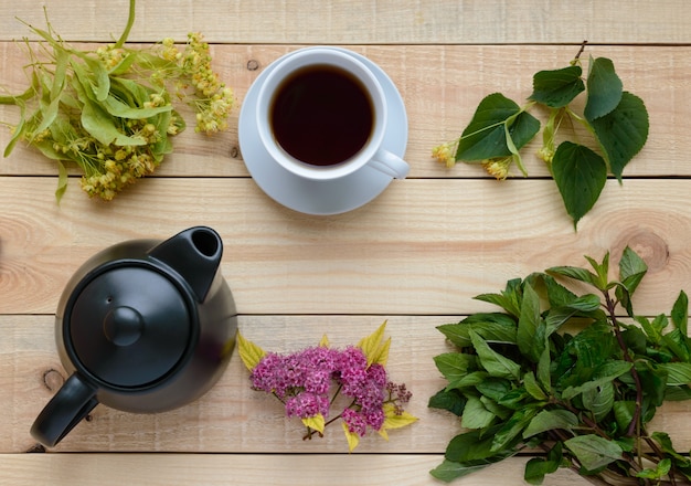 Linden flowers and tea  and green mint on a light wood. Top view