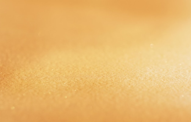 Line of focus defocused golden glitter background blurred\
sparkle sand texture of gold design paper