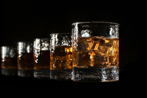 a line of four ice scotch glasses