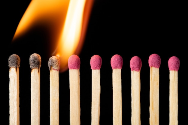 Photo line of matches igniting one by one