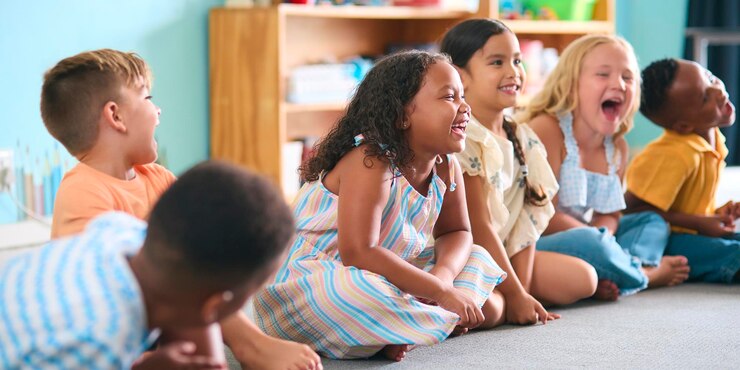 Photo line of smiling primary or elementary school students sitting on floor during classroom lesson