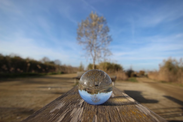 Foto sfera di cristallo di prospettiva lineare sul tavolo di legno del campo