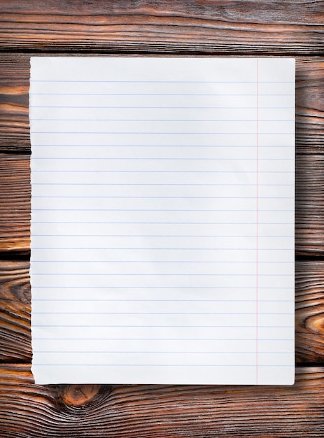 Lined paper on a dark wooden table