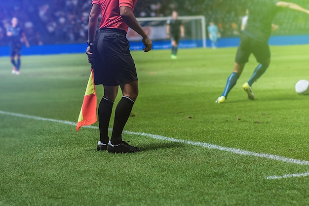 Lineman assistent-scheidsrechter met vlag Officiële voetbalspel naast voetbalveld.