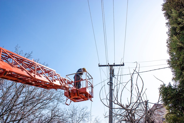 Photo lineman duty working fix power line on electrical cable with aerial work platforms