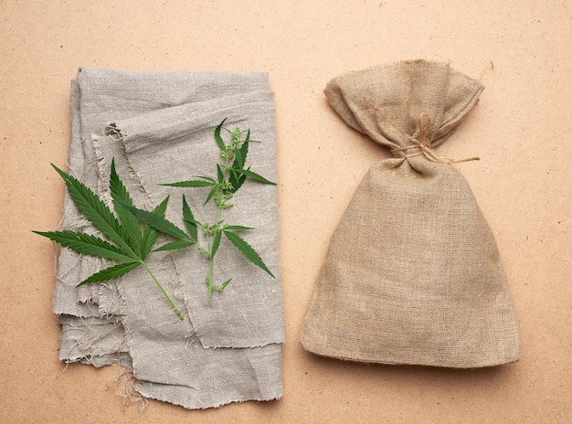 Photo linen green hemp leaf brown bag on a brown wooden background concept of rejection