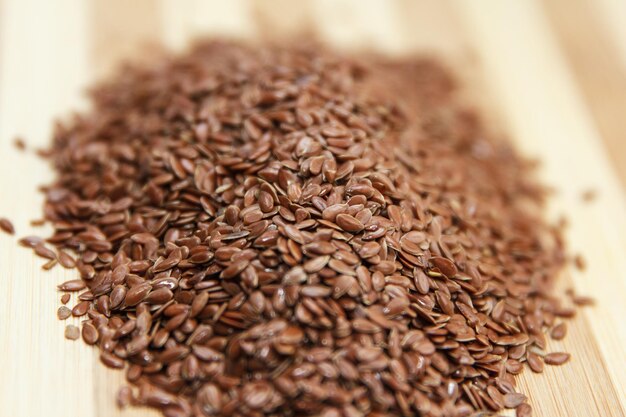 Linen raw seeds lie on a wooden surface in the kitchen prepared for cooking use