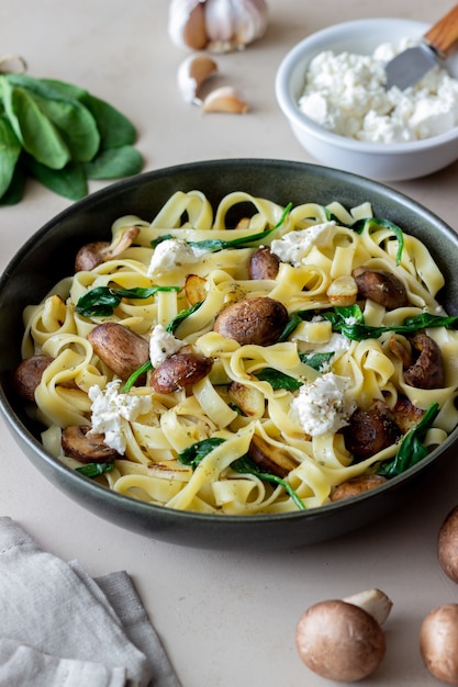 Linguine pasta with mushrooms, white cheese, spinach and\
garlic. healthy eating. vegetarian food. diet.