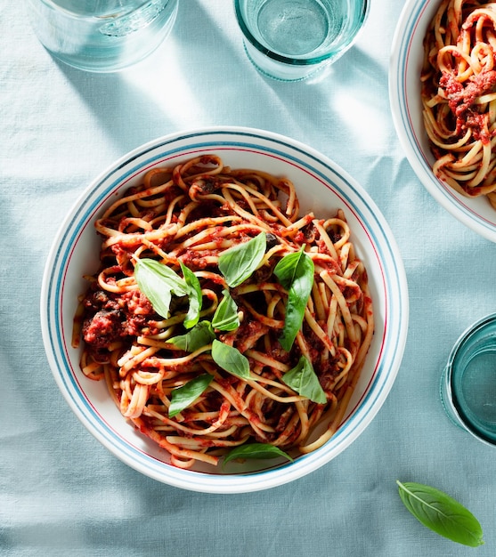 Linguine pasta with tomato sauce and fresh basil on the table