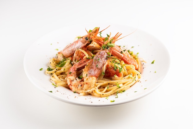 Linguine with garlic and king prawns on a plate on whita background