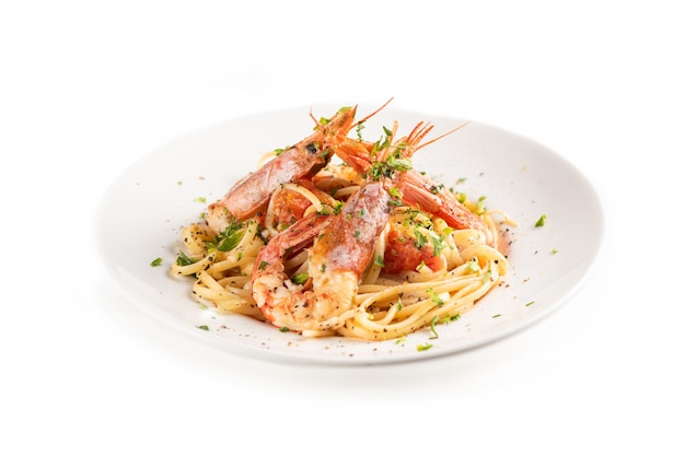 Linguine with garlic and king prawns on a plate on whita background