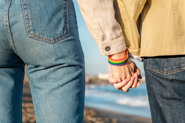 Photo linked hands with rainbow flag bracelet