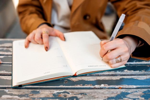Linkshandige persoon die op een notitieboekje in een café schrijft