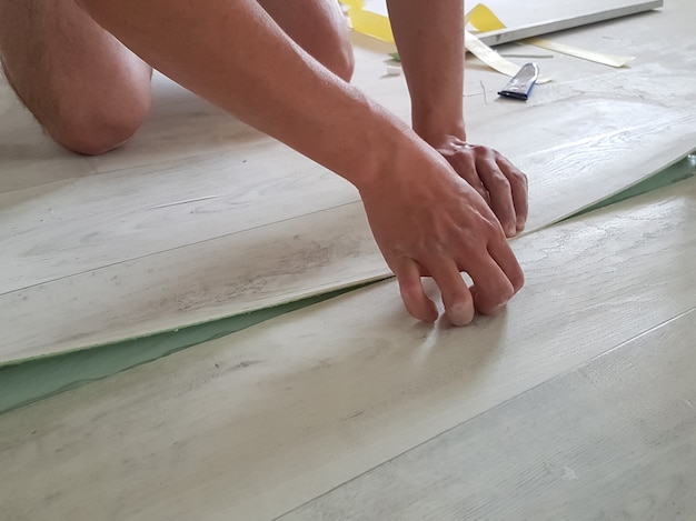 Linoleum installation. Worker glues linoleum parts