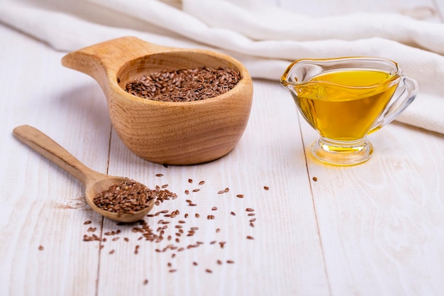 Linseed oil in a glass vessel and closeup flax seeds The concept of healthy eating