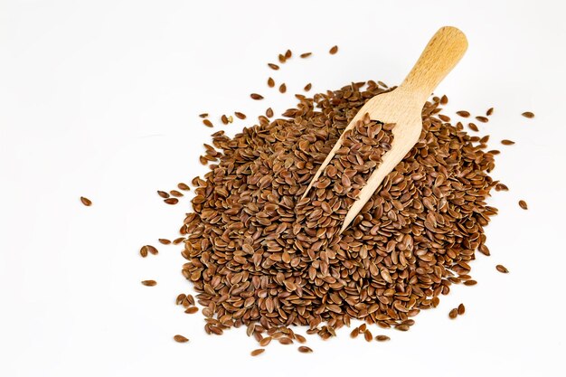 linum usitatissimum is scientific name of brown flax seed. also known as linseed, flaxseed and common flax. pile of grains, isolated white background.