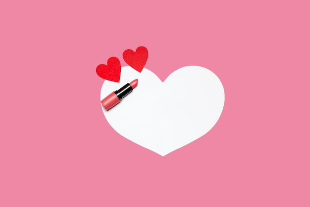 lippenstift en kleine harten op een roze-witte achtergrond