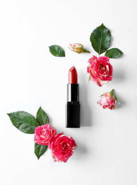 Foto lippenstift met mooie bloemen op witte achtergrond