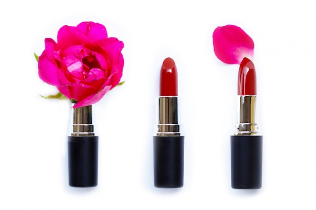 Lippenstiften met roze bloem op witte achtergrond.