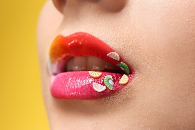 Lips of beautiful woman with creative makeup ob color background