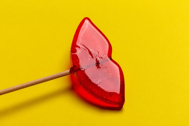 Lips lollipop on yellow background