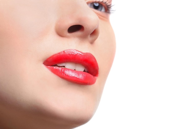 Foto primo piano di trucco delle labbra. rossetto rosso brillante. primo piano del viso del modello femminile con trucco lucido alla moda, concetto di bellezza isolato