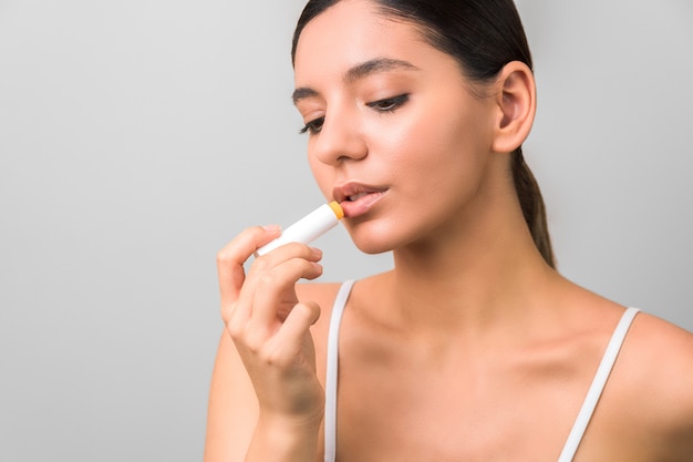 Lips protection and care. beauty woman applying balm on lips