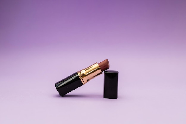 Lipstick in a bottle on a purple background