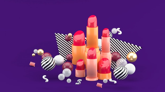 Lipstick among colorful balls on purple. 3d rendering.