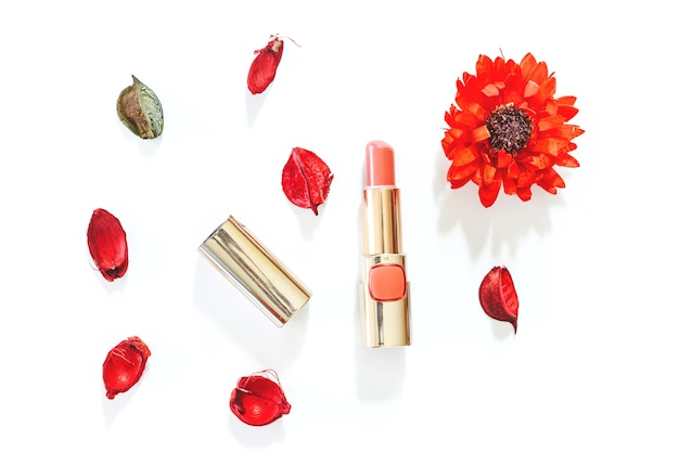 lipstick and flowers on white background
