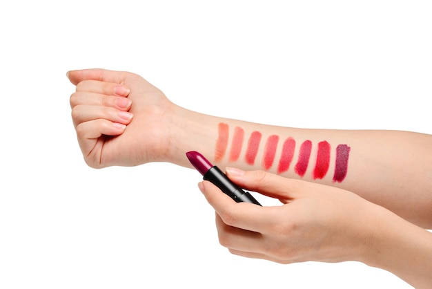 Lipstick swatches on woman hand isolated on white background