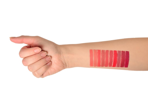 Lipstick swatches on woman hand isolated on white background.