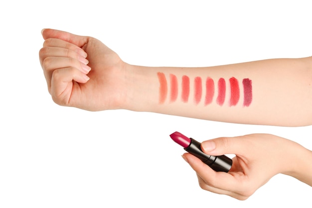 Lipstick swatches on woman hand isolated on white background