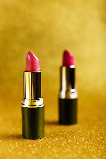 Lipsticks on golden glittery background.