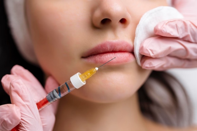 Lipvormcorrectieprocedure in een schoonheidssalon De specialist maakt een injectie op de lippen van de patiënt Lipvergroting